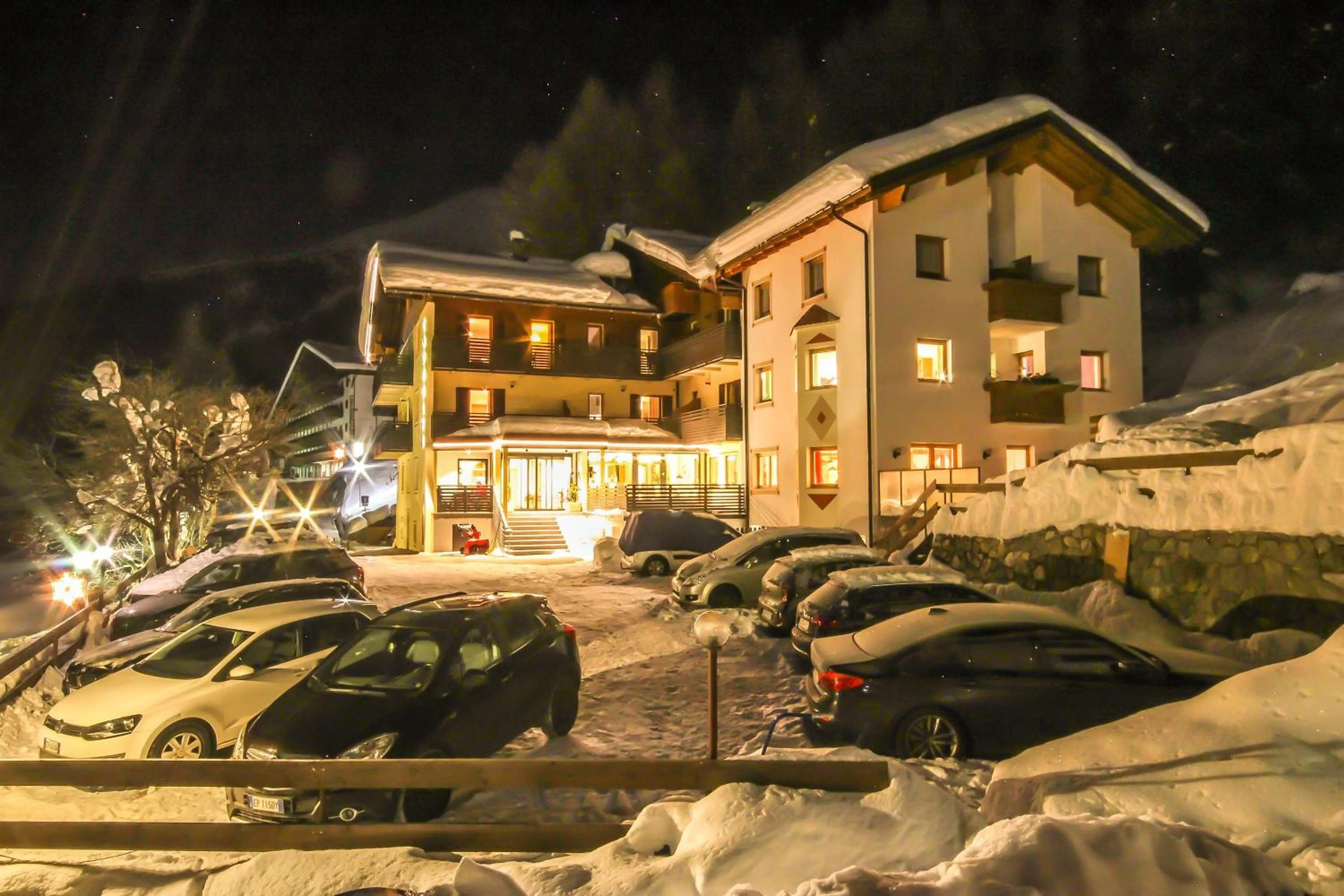 Das Hotel Cornelia im Winter bei Nacht, beleuchtet im tiefen Schnee