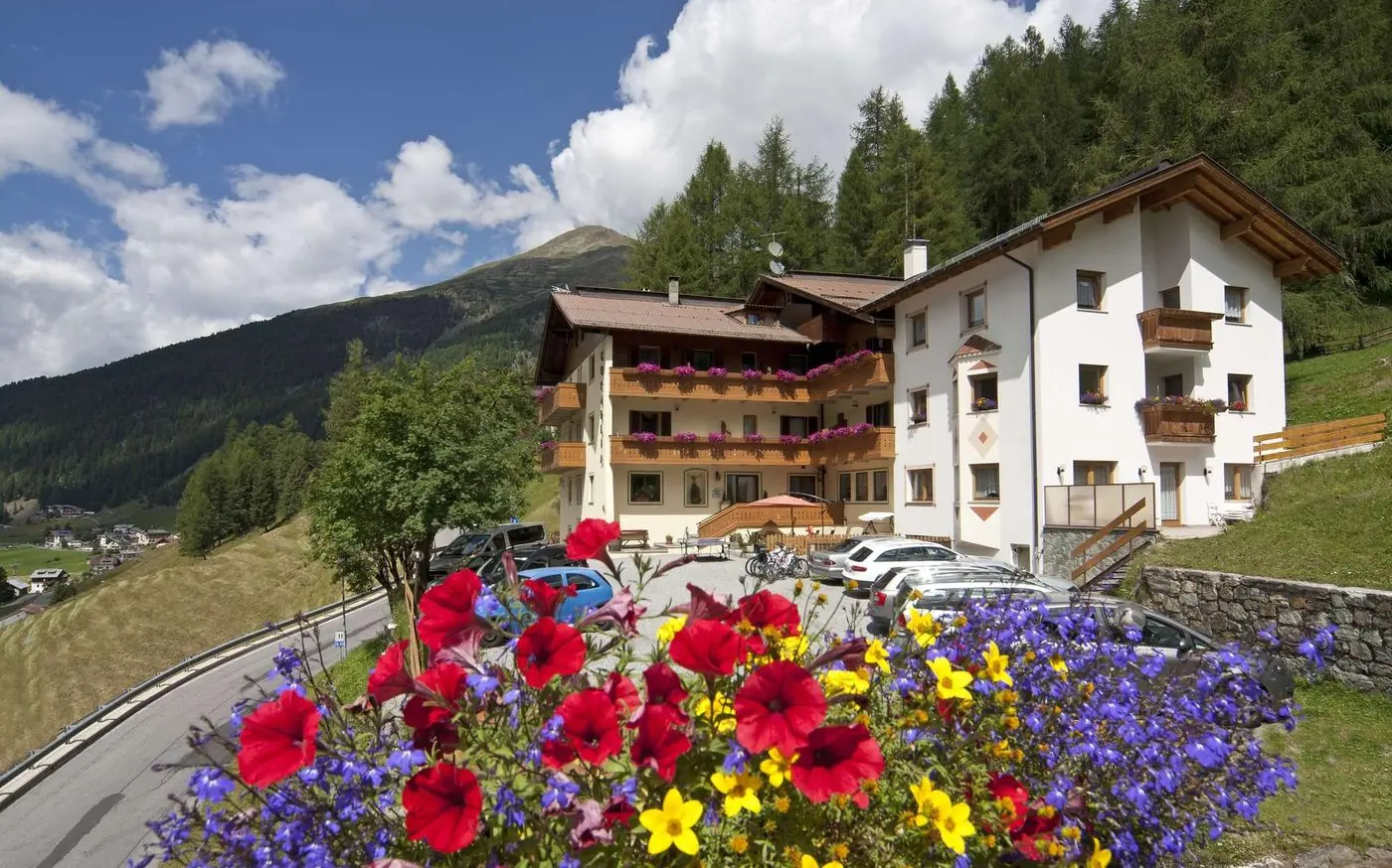 Das Hotel Cornelia im Sommer, davor Blumen