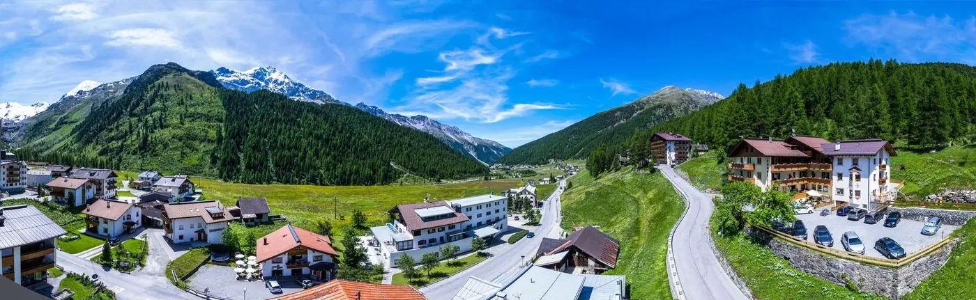 Luftbild über Sulden und das grüne Suldental im Sommer, rechts das Hotel Cornelia